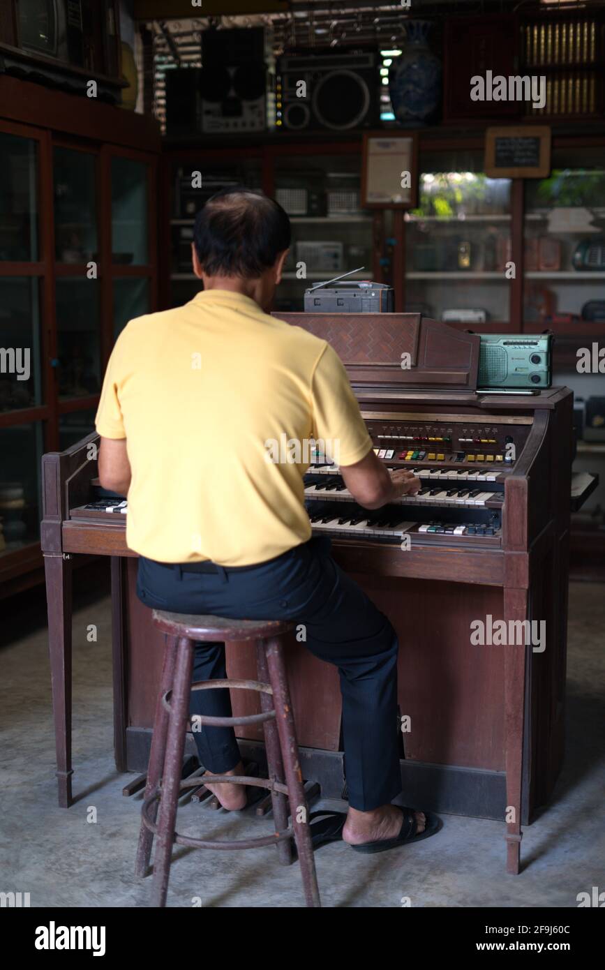 Der alte asiatische Mann spielte Klavier. Retro-Style. Bangkok, Thailand, 5. Januar 2020. Stockfoto