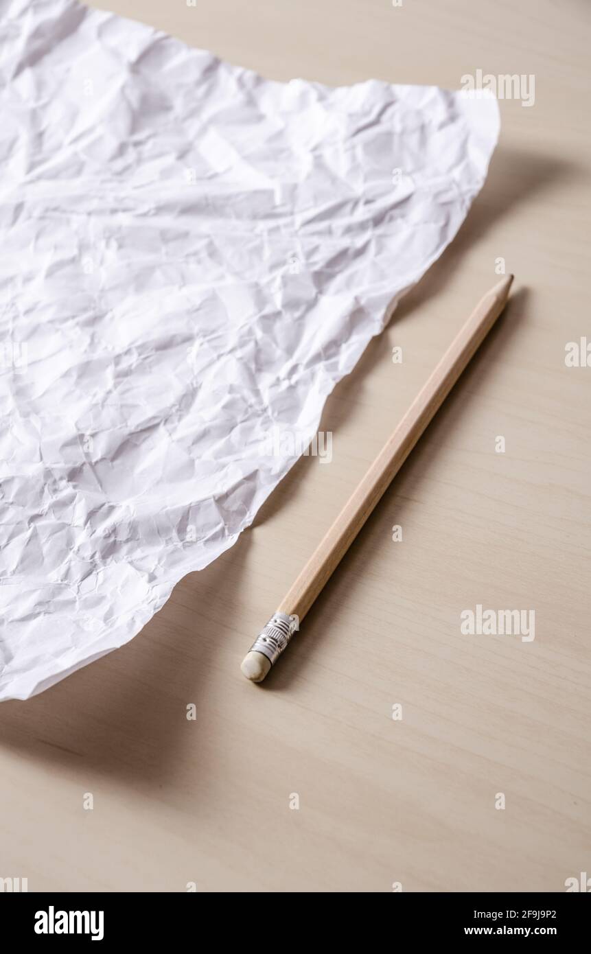 Zerknittert leeres leeres Blatt Papier und Bleistift auf Holzschreibtisch, Schreibkonzept, drinnen, Home-Office-Arbeit Stockfoto