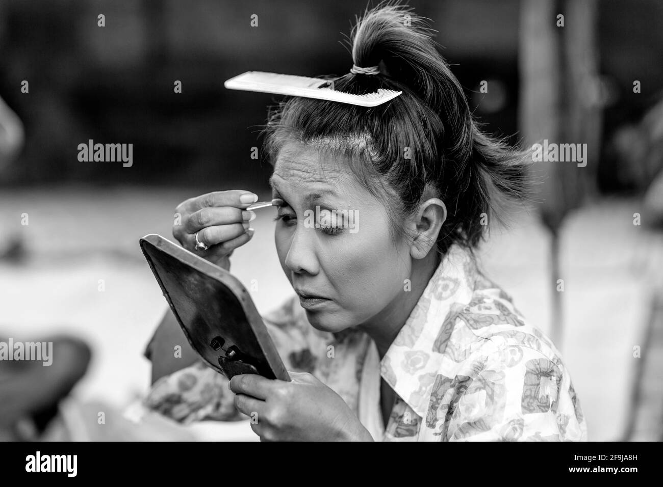 Eine Frau wendet Make Up an, bevor sie in EINER traditionellen balinesischen Barong und Kris Dance Show, Batabulaan, Bali, Indonesien, auftrat. Stockfoto