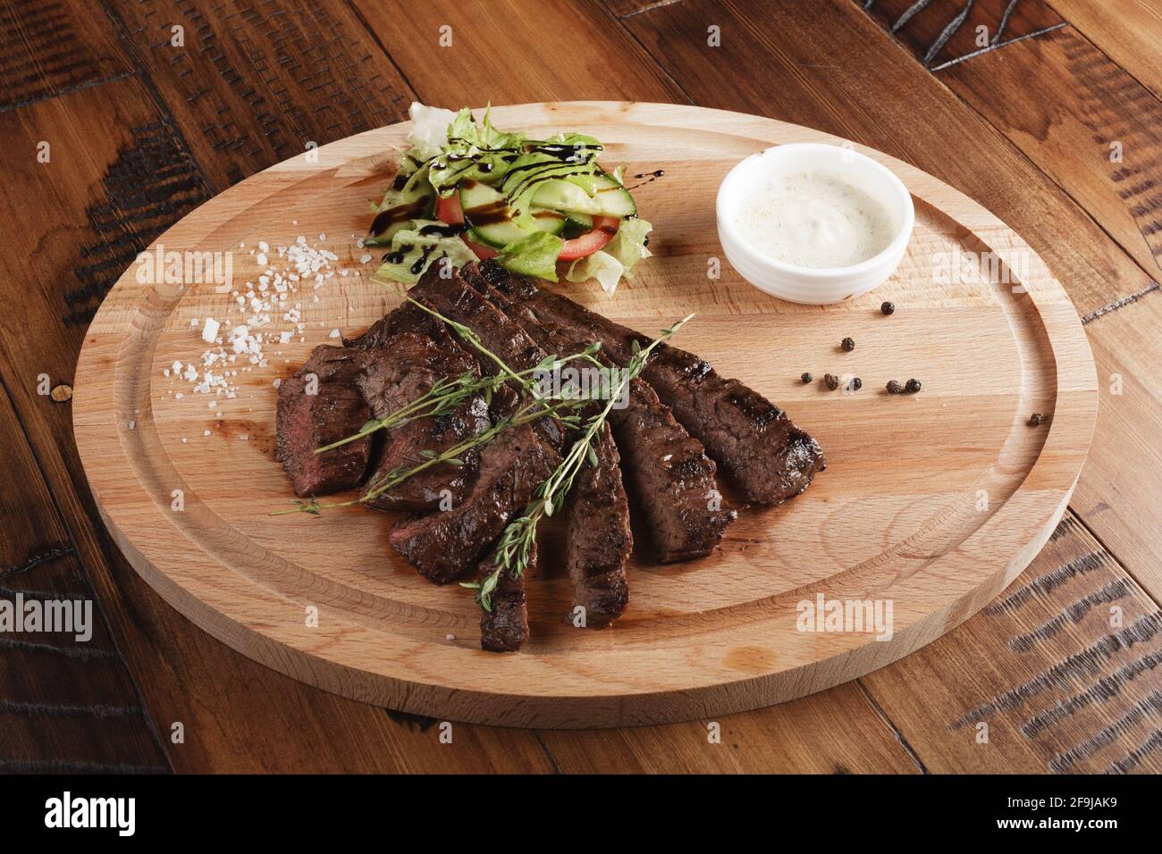 Rocksteak mit Salat und Sauce. Holzhintergrund Stockfoto