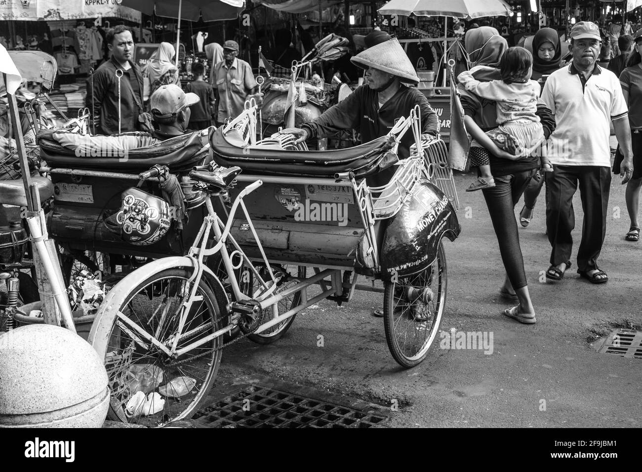 Ein traditionelles Becak (Radrickshaw) und Fahrer, Malioboro Street, Yogyakarta, Indonesien. Stockfoto