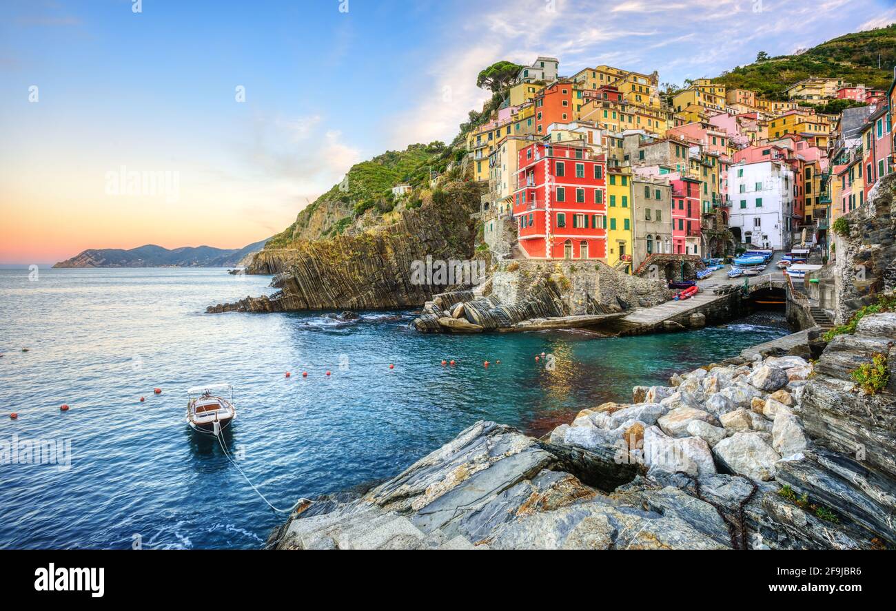 Bunte Häuser auf einem Felsen über dem Mittelmeer in Riomaggiore, einem der fünf Dörfer an der Küste von Cinque Terre, Ligurien, Italien Stockfoto