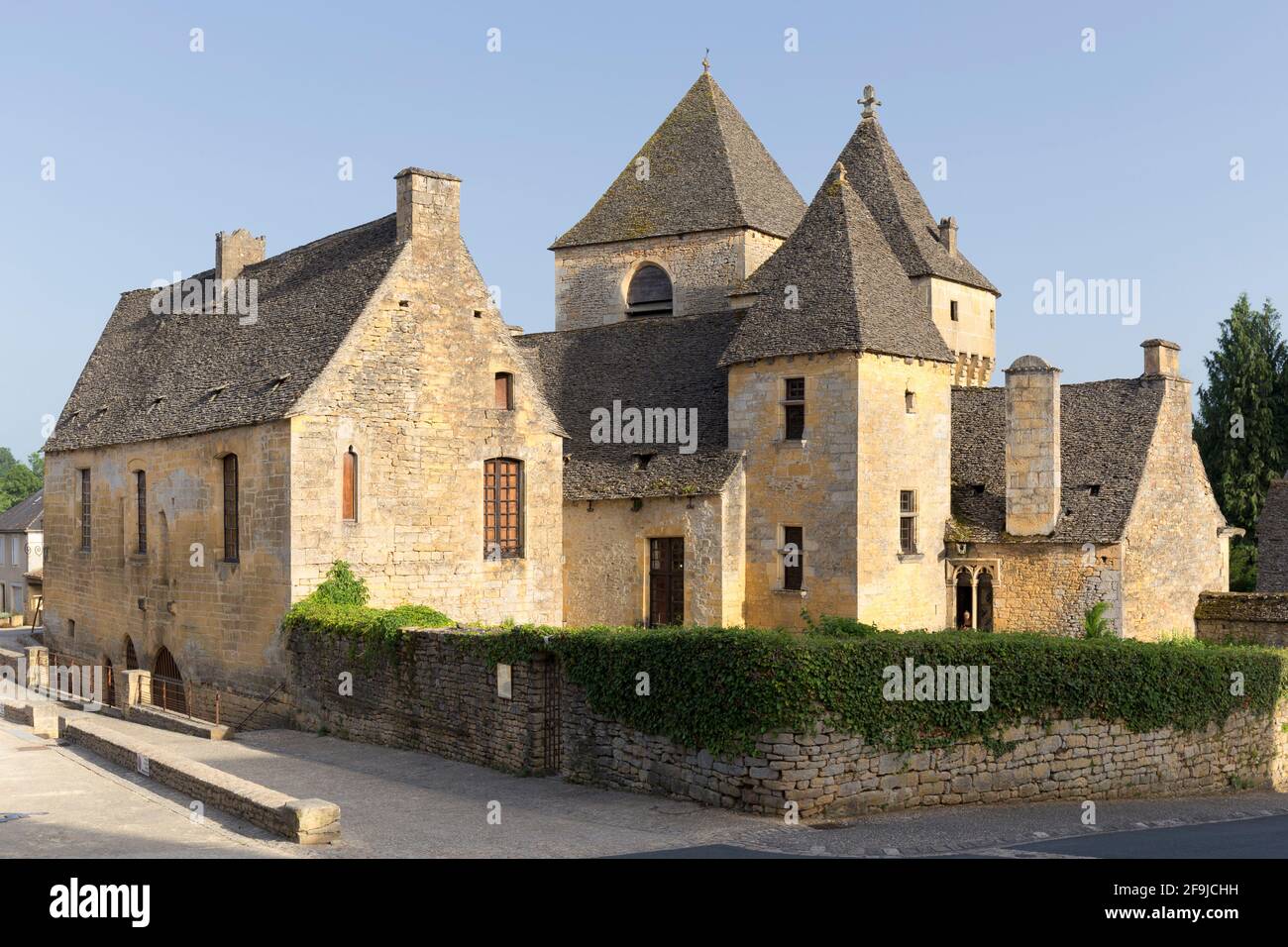 Die Kirche Notre Dame de l'Assomption und das angrenzende Schloss im Zentrum von Saint-Geniès, Dordogne, Frankreich Stockfoto