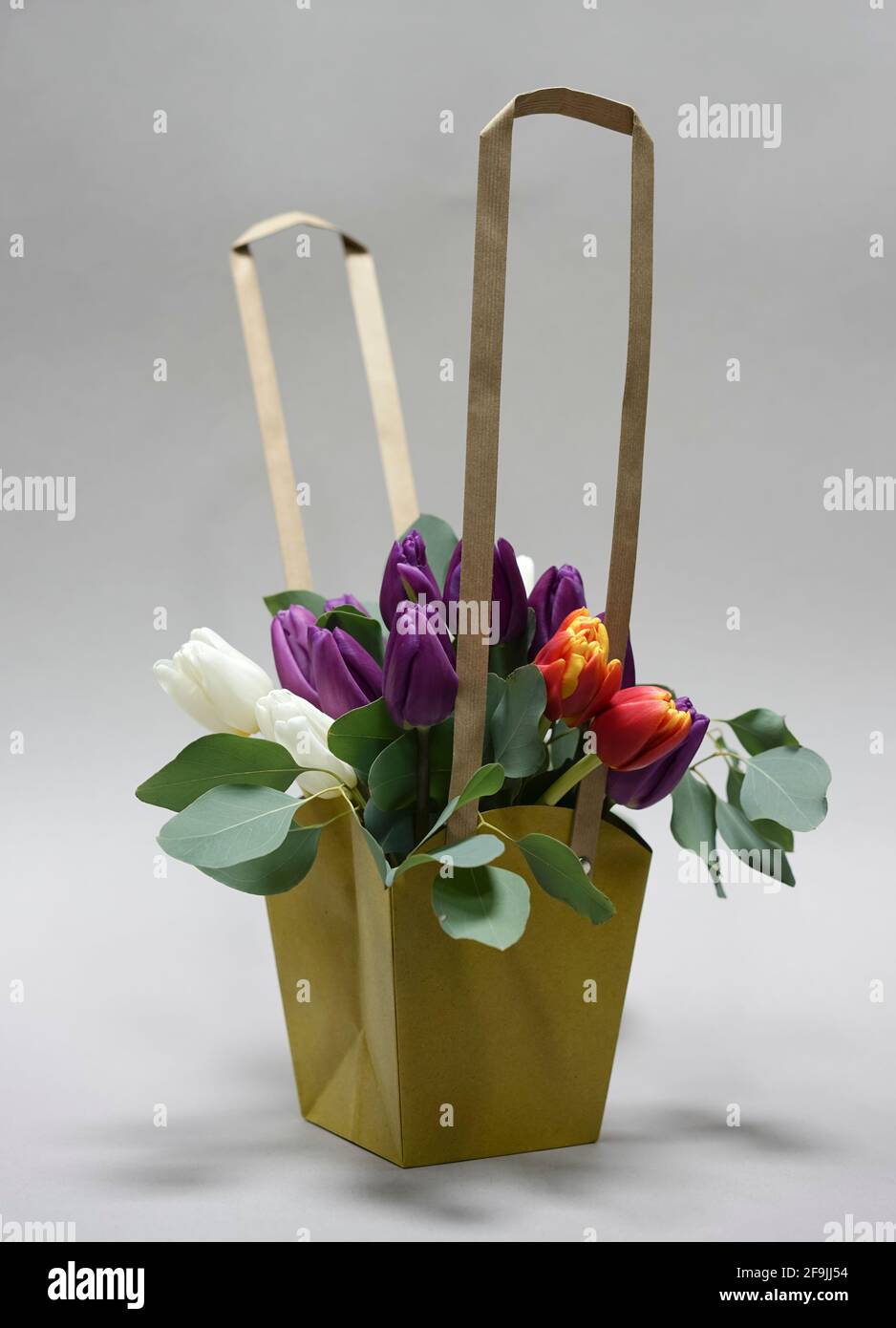 Bouquet von Tulpen in einem dekorativen Papierkorb auf einem Weißer Hintergrund Stockfoto