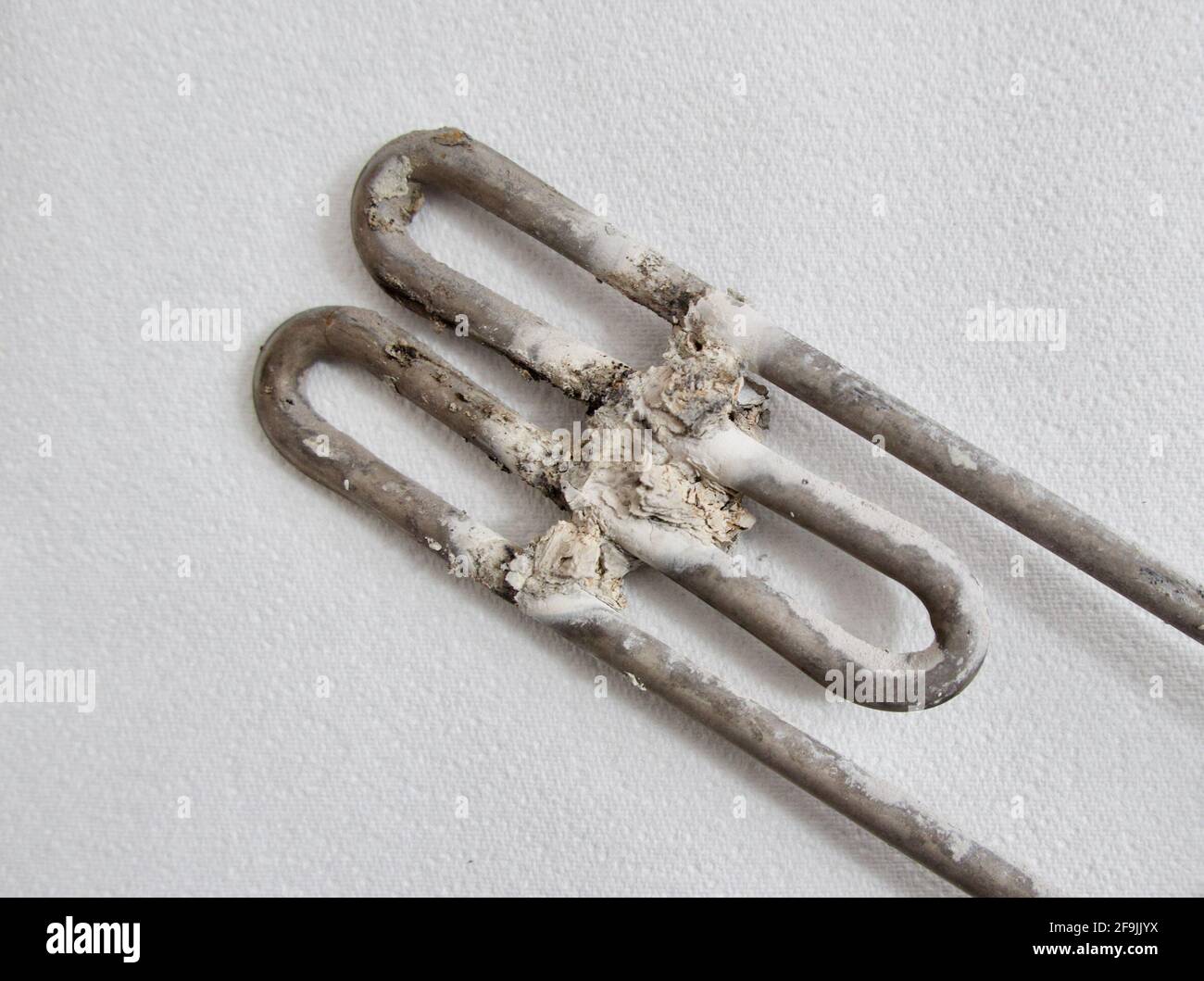 Nahaufnahme ausgebranntes Heizelement für Haushaltsgeräte gegen Weiß Hintergrund Stockfoto