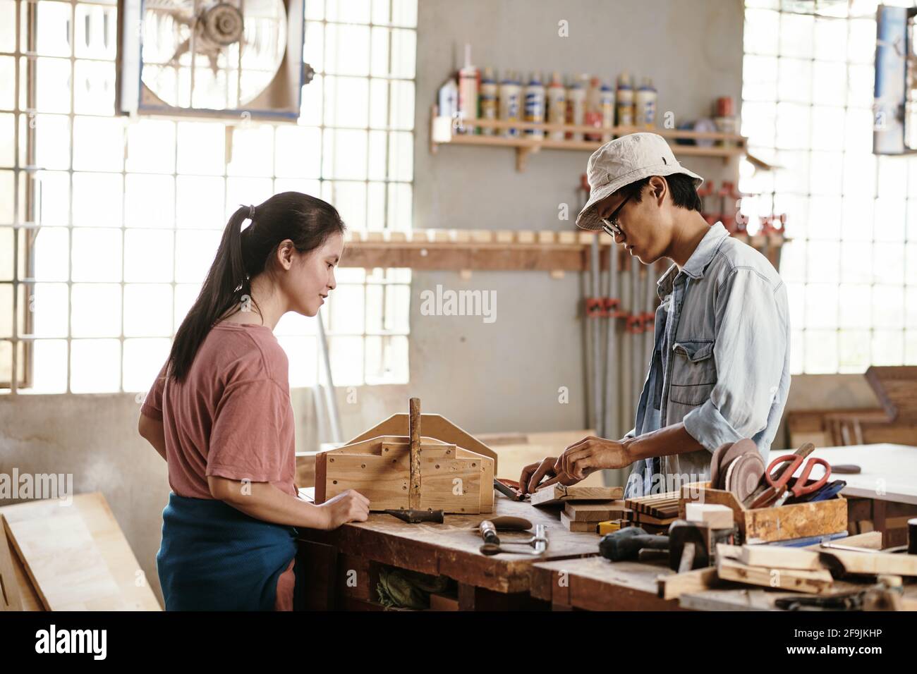 Junge vietnamesische Tischler, die mit Holzbohlen und Blöcken arbeiten umgebung Stockfoto