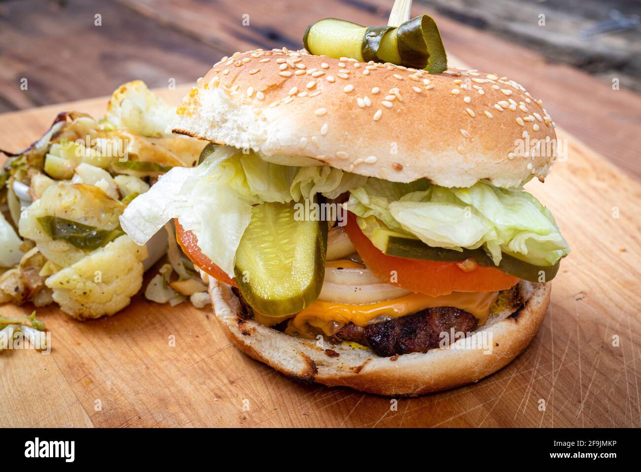 Köstlicher hausgemachter Käse-Burger mit Dill-Pickles aus der Nähe Holztisch Stockfoto