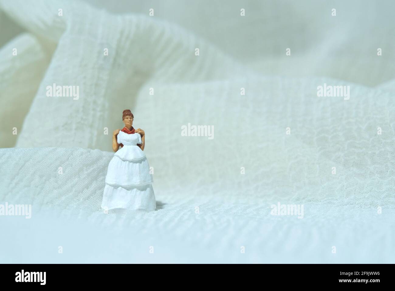 Frauen Miniatur Menschen versuchen, Hochzeitskleid zu wählen. Bildfoto Stockfoto