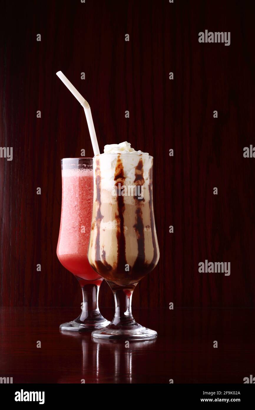Erdbeer-Smoothie und Affogato, ein italienisches Espresso-Getränk auf Kaffeebasis mit einer Kugel Vanilleeis und Schlagsahne über Holzbackgro Stockfoto