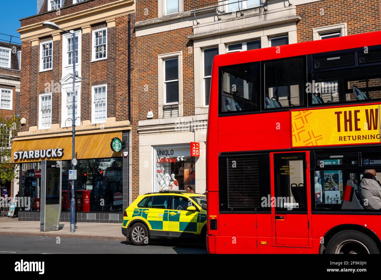 Kingston upon Thames London, 19 2021. April, Red London Doppeldeck-Bus, der einen geparkten First Responder Krankenwagen auf EINER High Street passiert Stockfoto