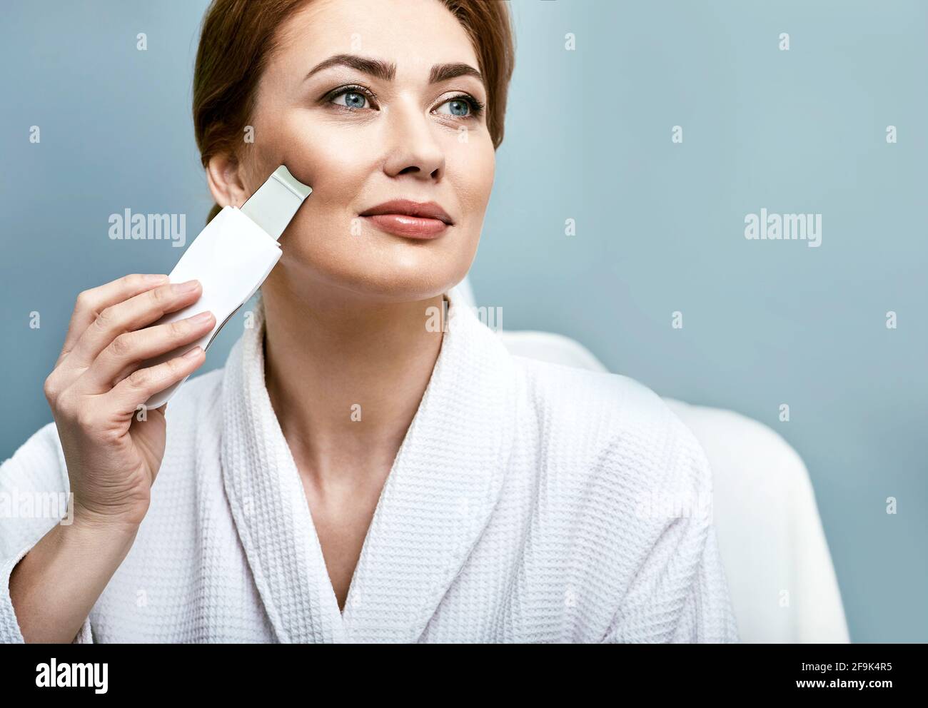 Ultraschall-Gesichtspeeling für das Gesicht einer Frau mit Ultraschallschrubber. Reinigende Gesichtshaut Stockfoto