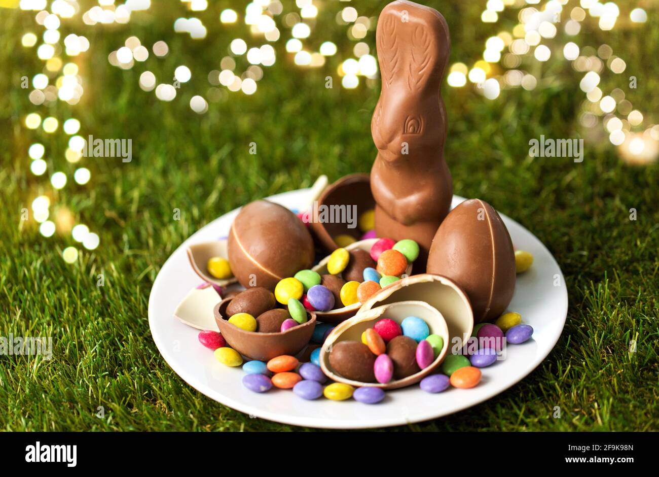 Schokoladenhasen, Eier und Bonbons auf Platte Stockfoto