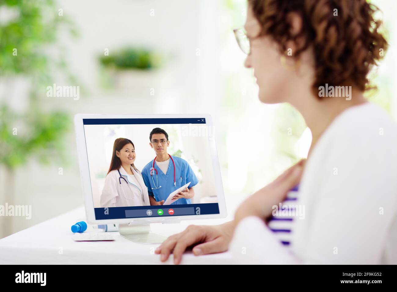 Kranke Frau beim Anruf zum Arzt. Online-Video-Chat und Telefonkonferenz mit medizinischem Personal des Krankenhauses. Kranker Patient hustet. Ausbruch des Coronavirus. Stockfoto