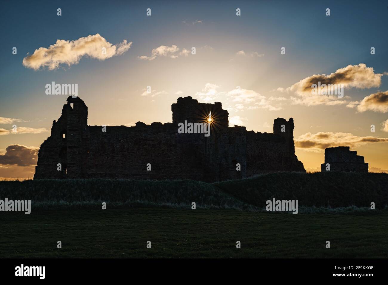 Sonnenaufgang im Morgengrauen über dem ruinierten mittelalterlichen Schloss von Tantallon mit Sonneneinbruch und blauem Himmel, East Lothian, Schottland, Großbritannien Stockfoto