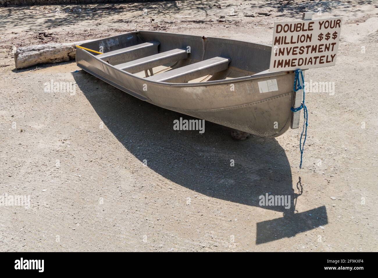 CAYE CAULKER, BELIZE - 2. MÄRZ 2016: Kleines Boot mit Schild verdoppelt Ihre Investition auf Caye Caulker Island, Belize Stockfoto