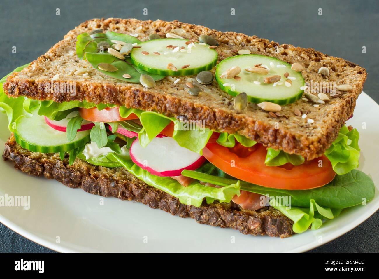 Hausgemachte gesunde Vollkornsandwiches mit Gemüse und geräuchertem Lachs. Leckeres Frühstück und gesundes Essen Konzept. Stockfoto