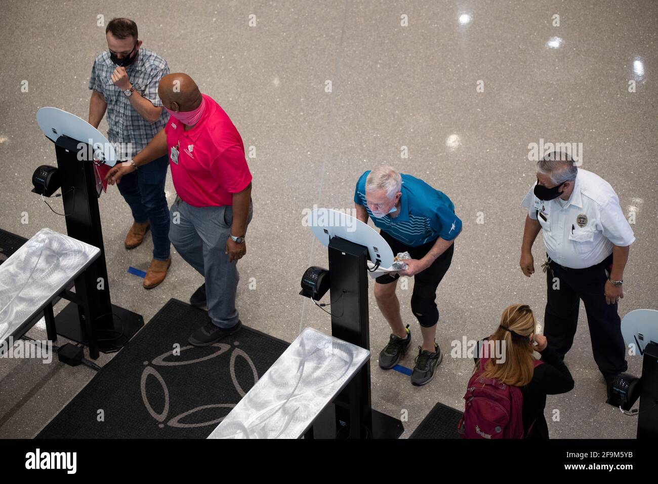 San Antonio, Texas 15. April 2021: Die Teilnehmer der Konferenz halten für eine berührungslose Temperaturkontrolle am Eingang des San Antonio Convention Center inne. Das Zentrum war im April nur Gastgeber seiner zweiten großen Funktion seit fast einem Jahr, nachdem Verbände und Unternehmen aufgrund der Coronavirus-Pandemie die Reiseaufenthalten von 2020 Personen reduziert hatten. ©Bob Daemmrich Stockfoto