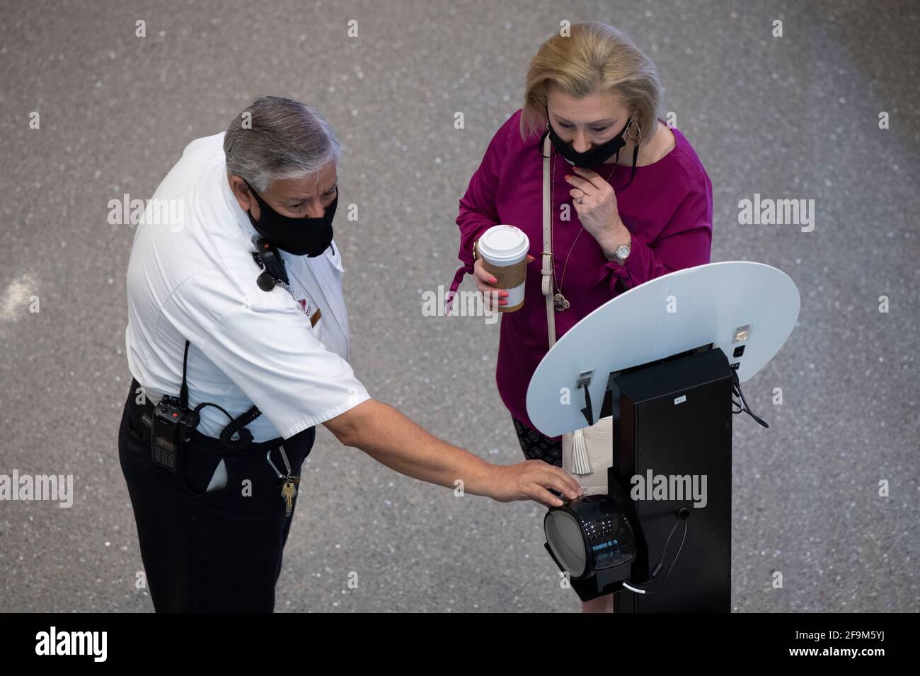 San Antonio, Texas 15. April 2021: Die Teilnehmer der Konferenz halten für eine berührungslose Temperaturkontrolle am Eingang des San Antonio Convention Center inne. Das Zentrum war im April nur Gastgeber seiner zweiten großen Funktion seit fast einem Jahr, nachdem Verbände und Unternehmen aufgrund der Coronavirus-Pandemie die Reiseaufenthalten von 2020 Personen reduziert hatten. ©Bob Daemmrich Stockfoto