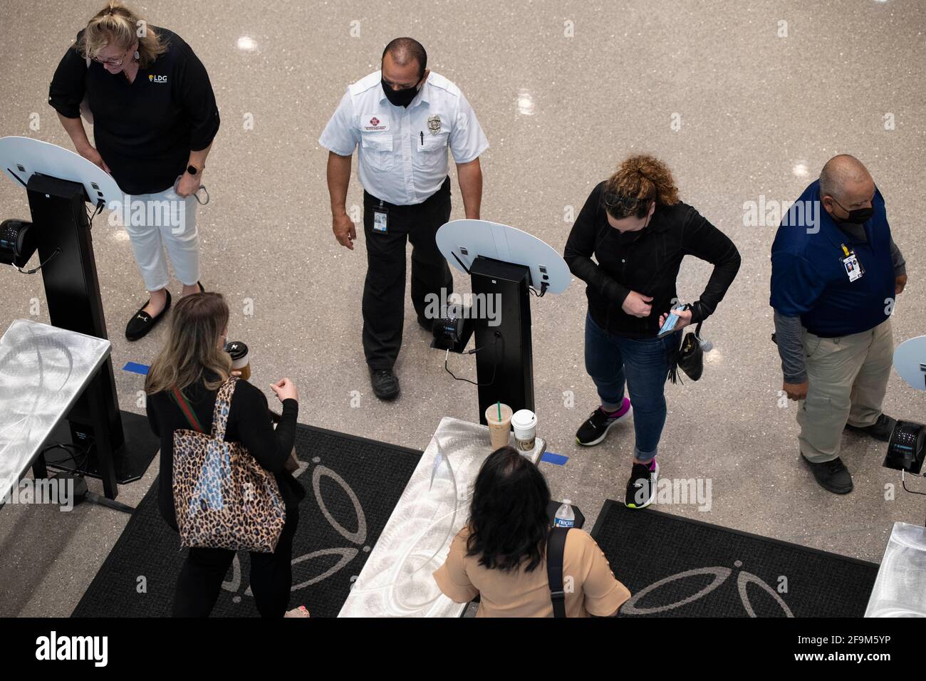 San Antonio, Texas 15. April 2021: Die Teilnehmer der Konferenz halten für eine berührungslose Temperaturkontrolle am Eingang des San Antonio Convention Center inne. Das Zentrum war im April nur Gastgeber seiner zweiten großen Funktion seit fast einem Jahr, nachdem Verbände und Unternehmen aufgrund der Coronavirus-Pandemie die Reiseaufenthalten von 2020 Personen reduziert hatten. ©Bob Daemmrich Stockfoto