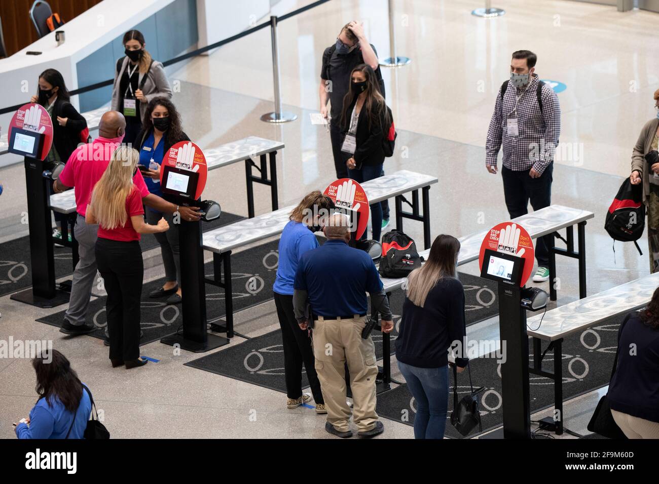 San Antonio, Texas 15. April 2021: Die Teilnehmer der Konferenz halten für eine berührungslose Temperaturkontrolle am Eingang des San Antonio Convention Center inne. Das Zentrum war im April nur Gastgeber seiner zweiten großen Funktion seit fast einem Jahr, nachdem Verbände und Unternehmen aufgrund der Coronavirus-Pandemie die Reiseaufenthalten von 2020 Personen reduziert hatten. ©Bob Daemmrich Stockfoto