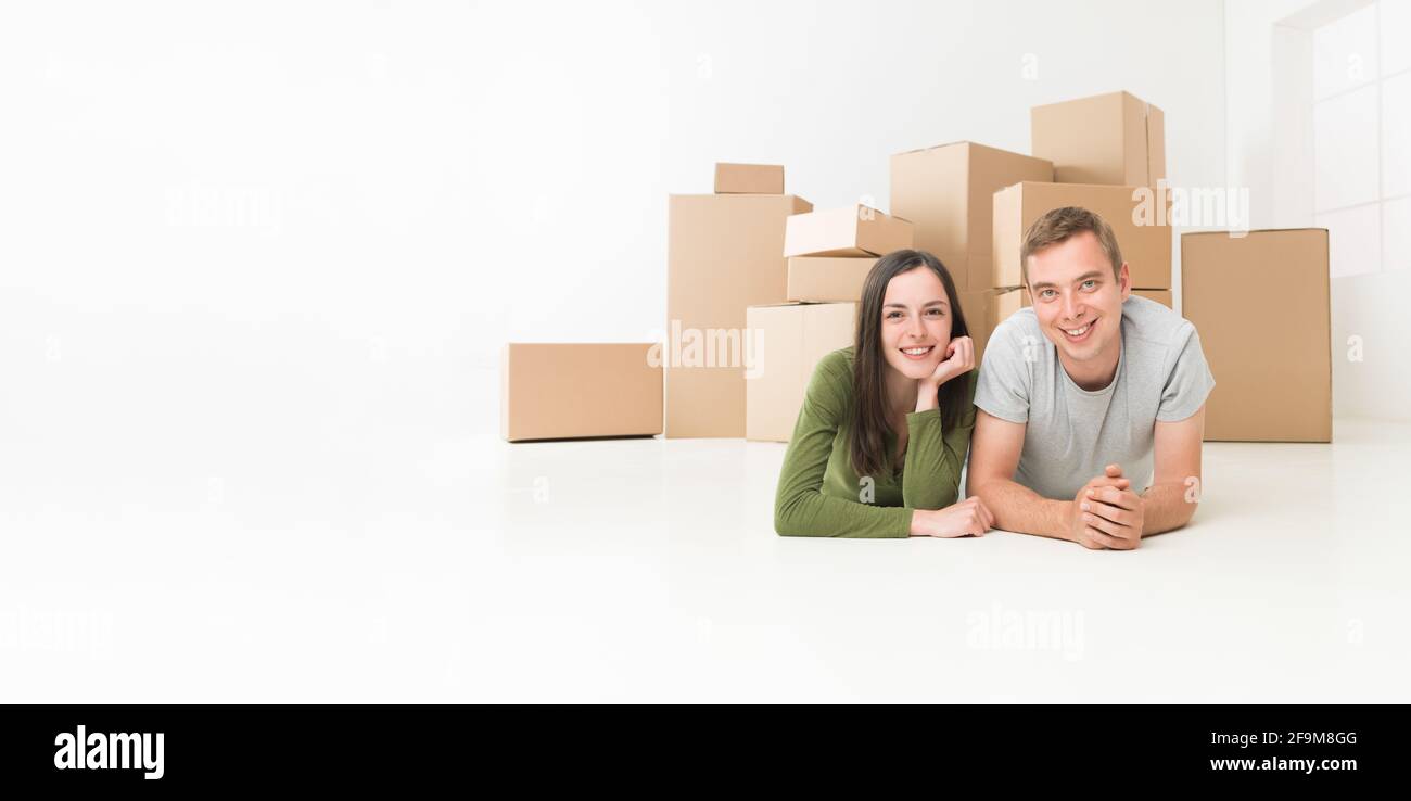 glückliches junges Paar am Boden in ihrem neuen Zuhause Stockfoto