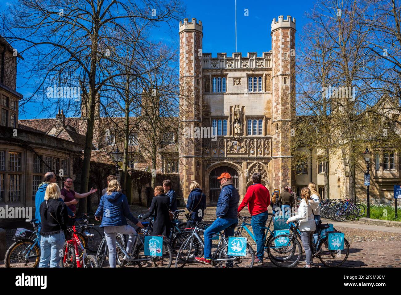 Cambridge Bike Tours Touristen halten mit einem Fremdenführer vor dem C16th Trinity College Great Gate inne. Fahrradtouren Durch Cambridge. Stockfoto