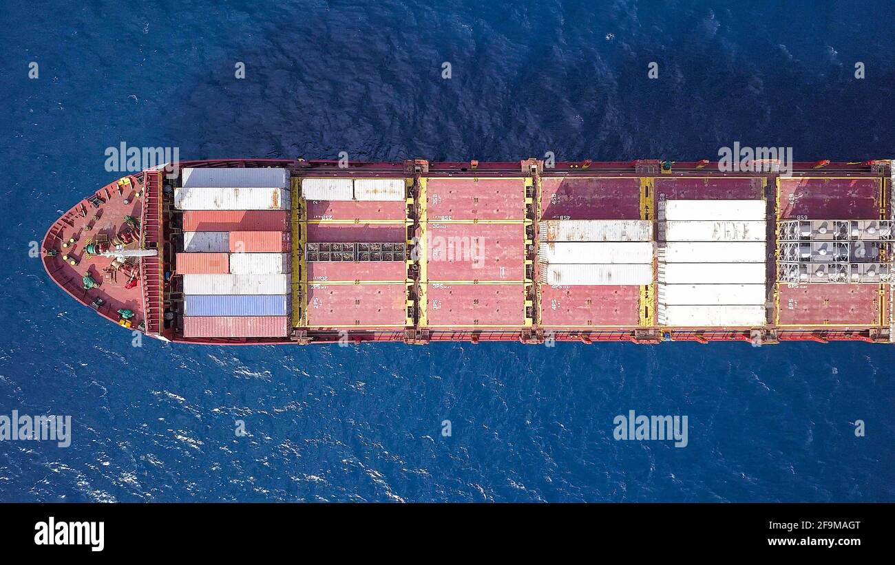 Großes Containerschiff, das mit verschiedenen Containermarken beladen ist. Stockfoto