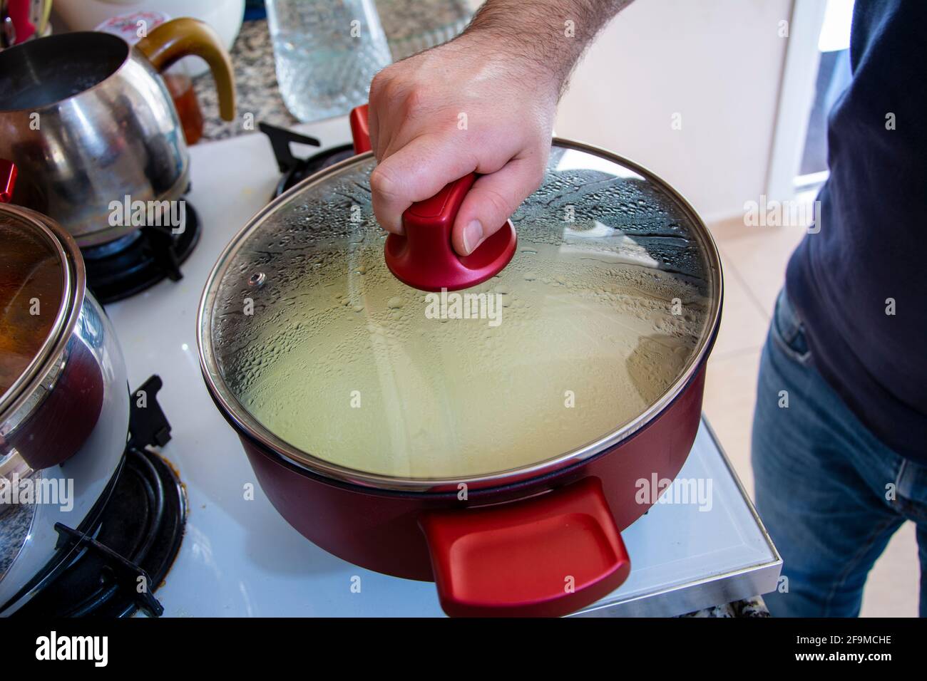 Schließen des Deckels eines Topfes zum Kochen von Reis in einem Nahaufnahme Stockfoto