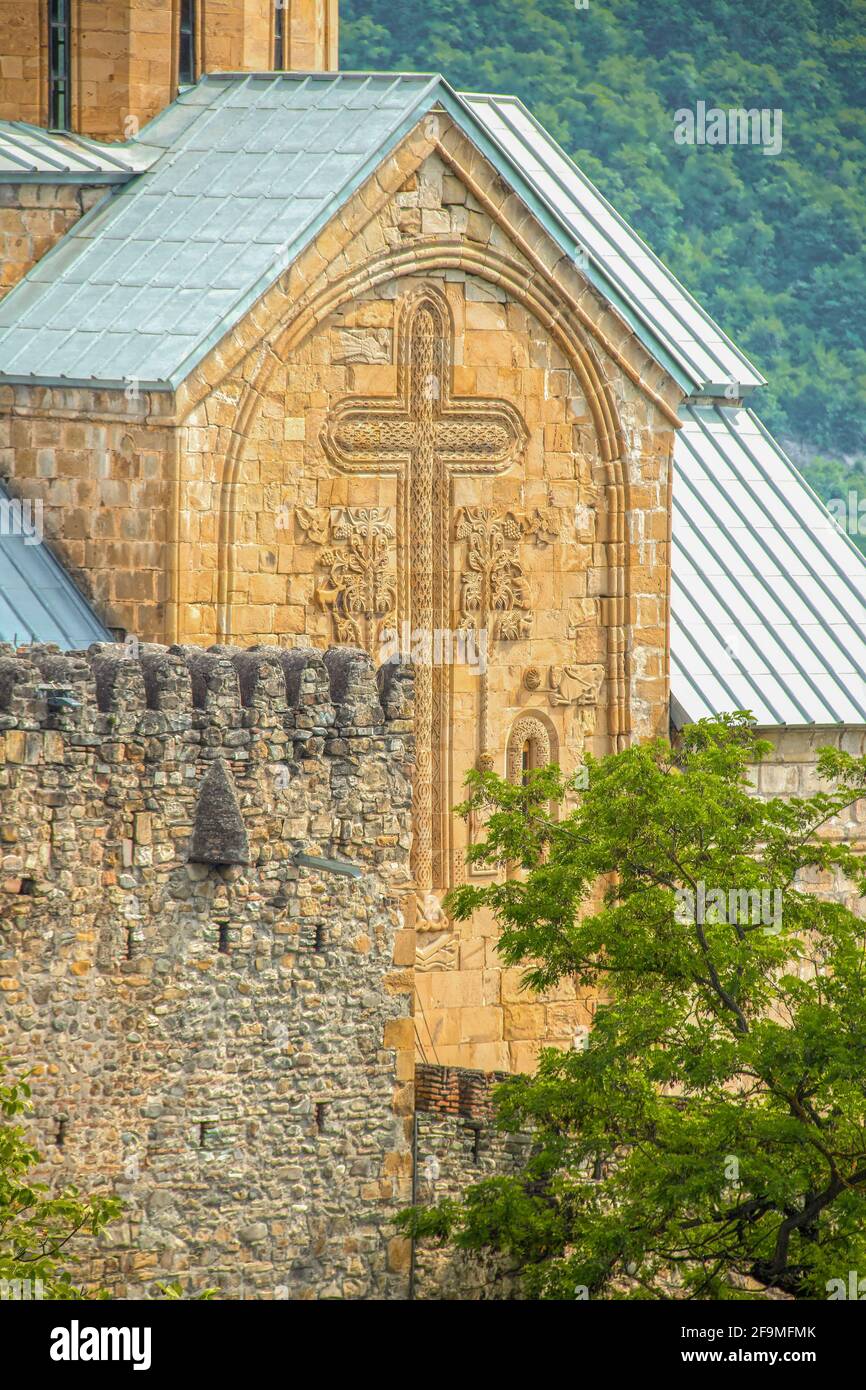 Jvari-Kloster - Georgisches UNESCO-Weltkulturerbe aus dem 6. Jahrhundert - Nahaufnahme Von geschnitzten Kreuz auf einem Turm mit alten Burg wie Struktur in vorwegr Stockfoto