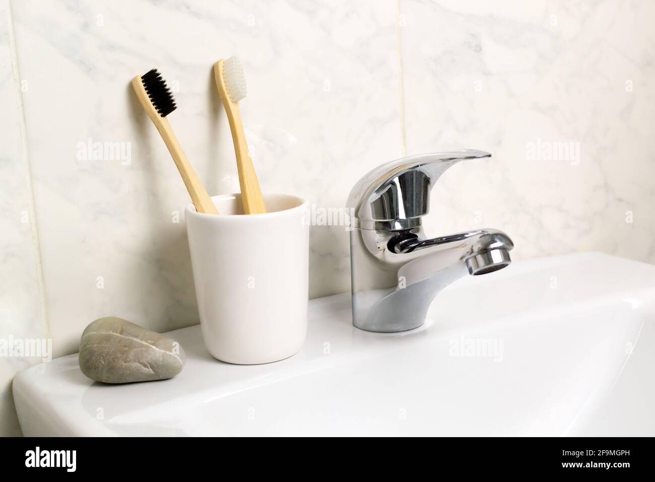 Im Badezimmer stehen zwei Bambuszahnbürsten in einem Glas. Umweltfreundliches Konzept. Horizontale Ausrichtung. Stockfoto