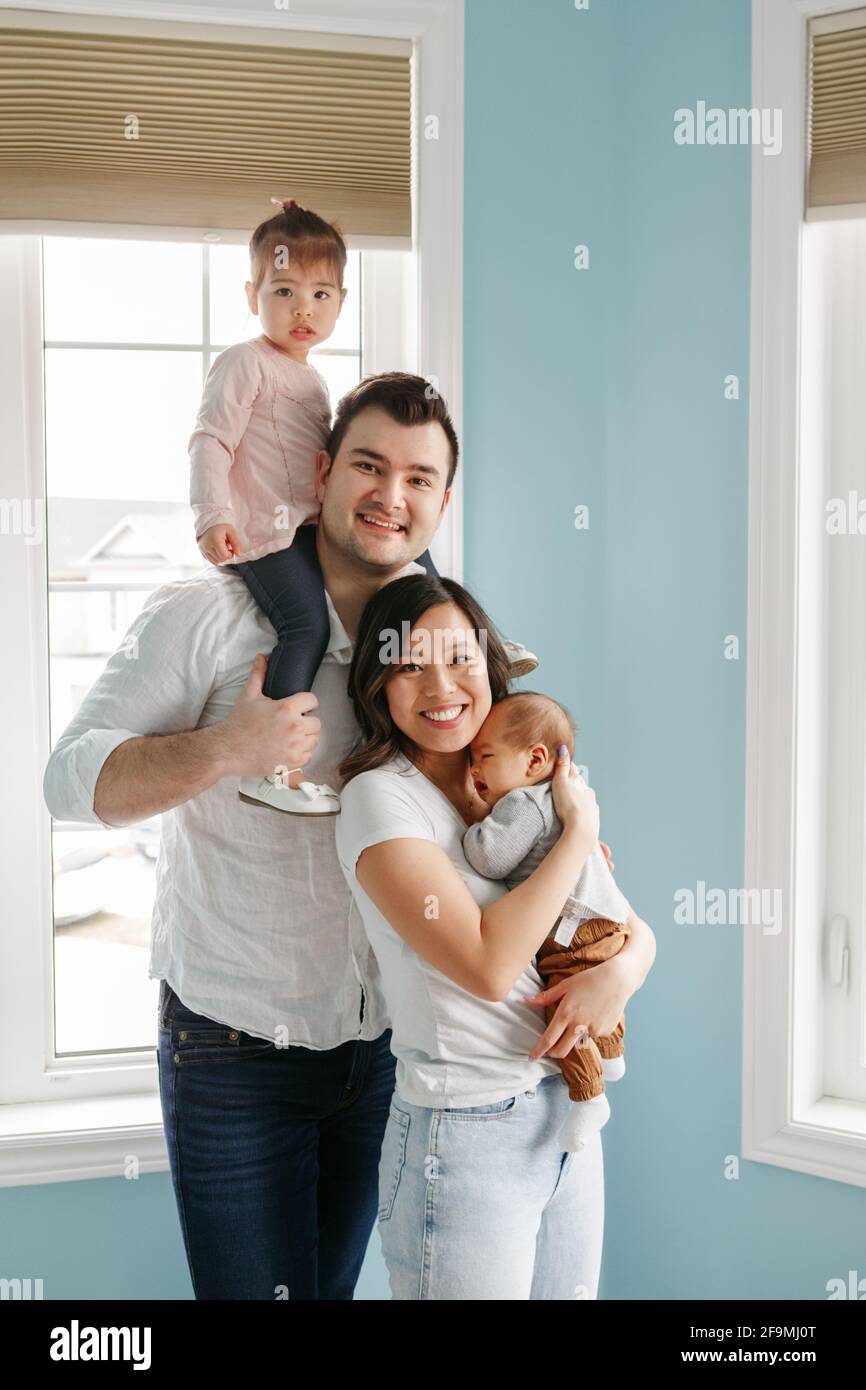 Glückliche Familie mit zwei kleinen Kindern zu Hause. Ethnische Vielfalt. Stockfoto