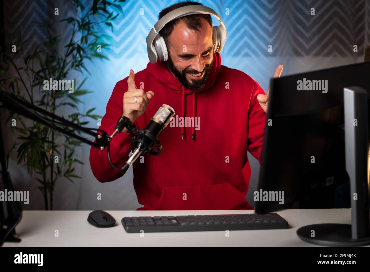 Content Creator mit Kopfhörern und Mikrofon, die ein Programm online im Internet streamen. Podcast-Moderator sendet On-Air-Programm. Aufzeichnung von Inhalten für Internetprogramme. Stockfoto