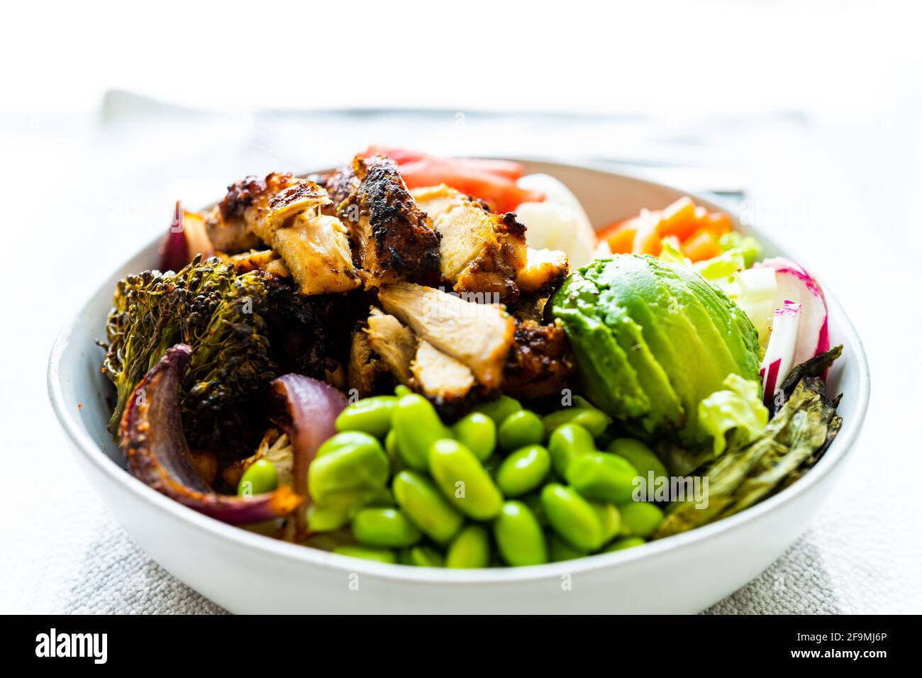 Gebratenes Huhn, Brokkoli, Edamame, Avocado-Salatschüssel zum Mittagessen Stockfoto