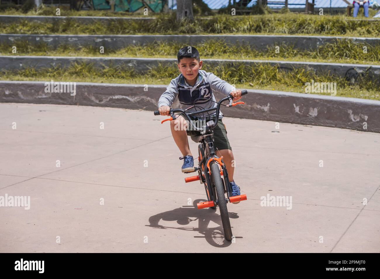 Junge, der mit seinem Fahrrad läuft. Stockfoto