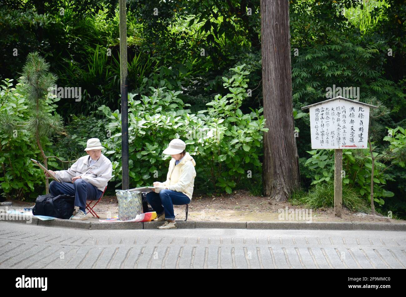 Ein Mann und eine Frau zeichnen und malen die Landschaft rund um den Engakuji-Tempel in der Präfektur Kamakura, Japan Stockfoto