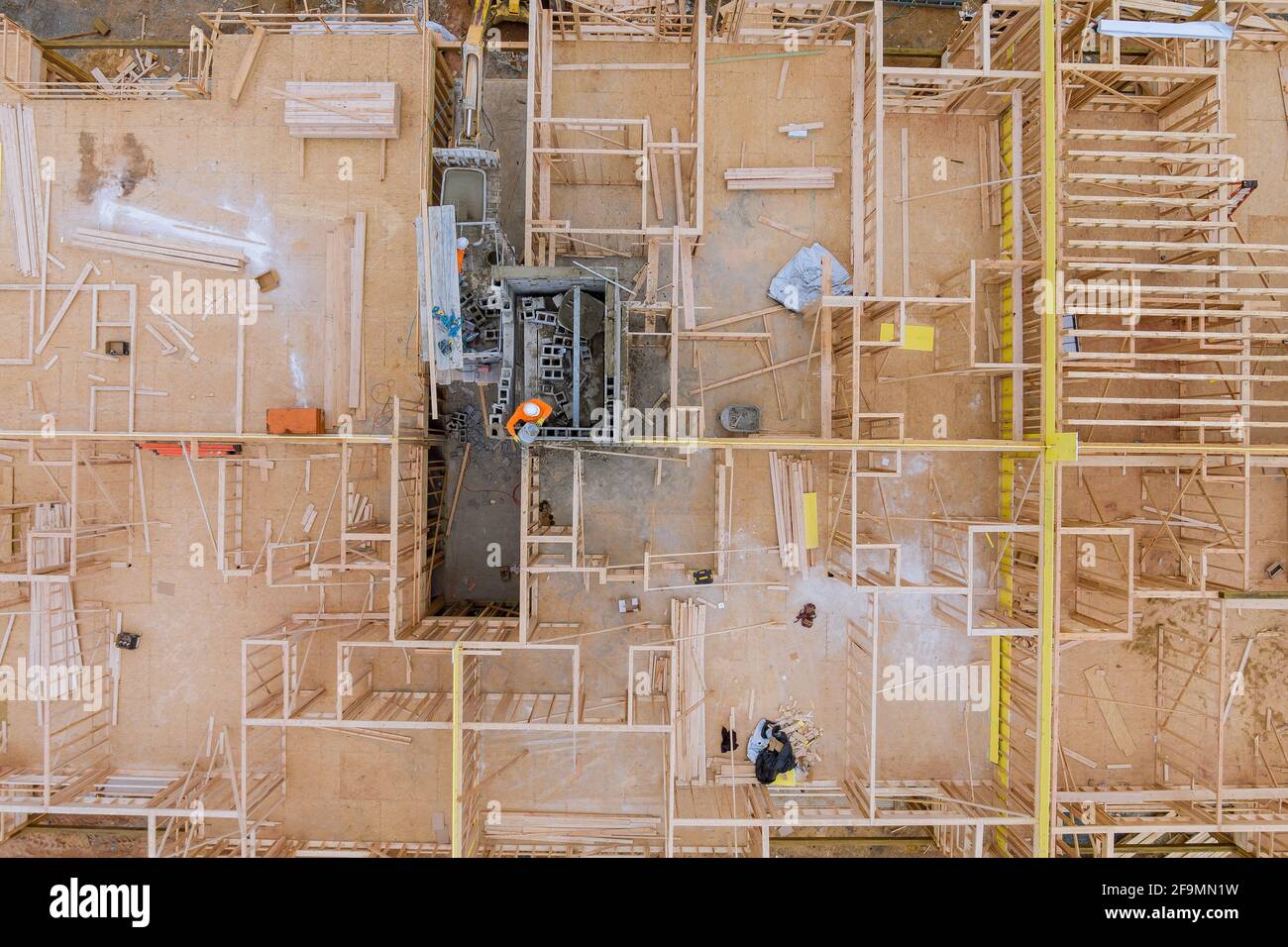 Luftaufnahme des Aufzugsschachts für Betonblockgebäude darunter Die Bauarbeiten an den Arbeitern sind Blockierungen Stockfoto