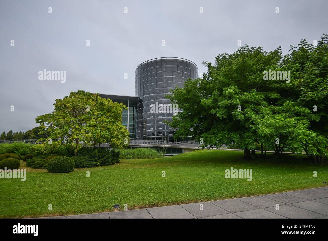 DEUTSCHLAND DRESDEN - AUGUST 2015: Panorama des Glasgebäudes des Volkswagen-Werks, Grünflächen in der Nähe eines Gebäudes. Glaeserne Manufaktur. Glasmanufaktur Volkswagen. Stockfoto