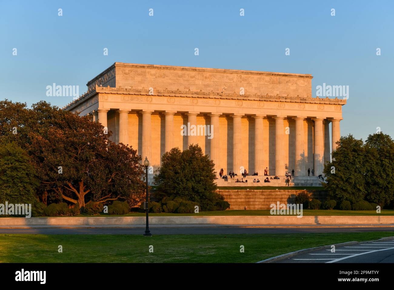 Washington, DC - 3. Apr 2021: Lincoln Memorial von hinten mit Zuschauern, die den Sonnenuntergang im Frühling in Washington, DC genießen Stockfoto