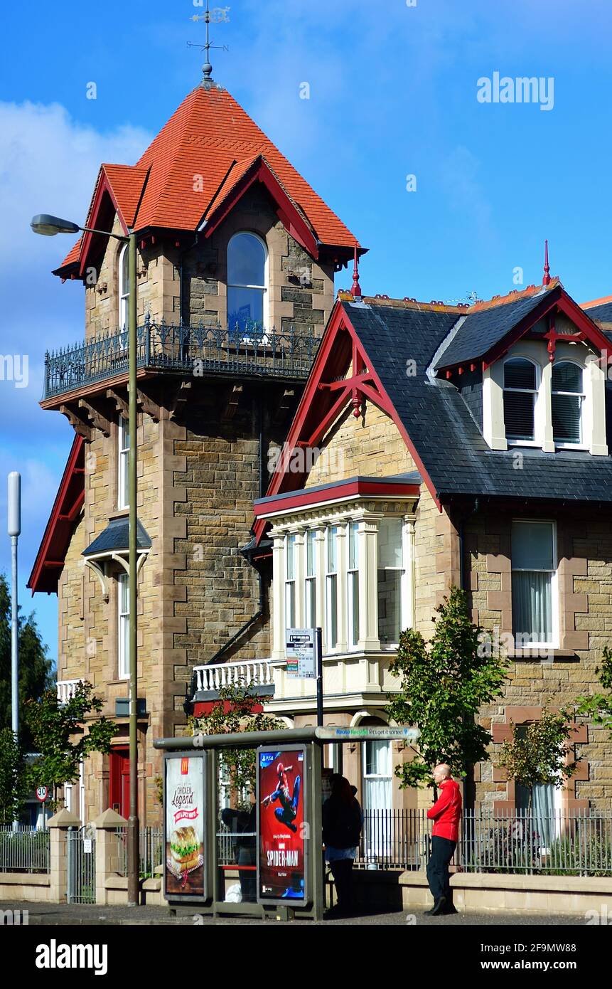 Edinburgh, Schottland, Großbritannien. Anfeigte Passagiere warten auf einen Stadtbus entlang einer Wohnstraße. Stockfoto