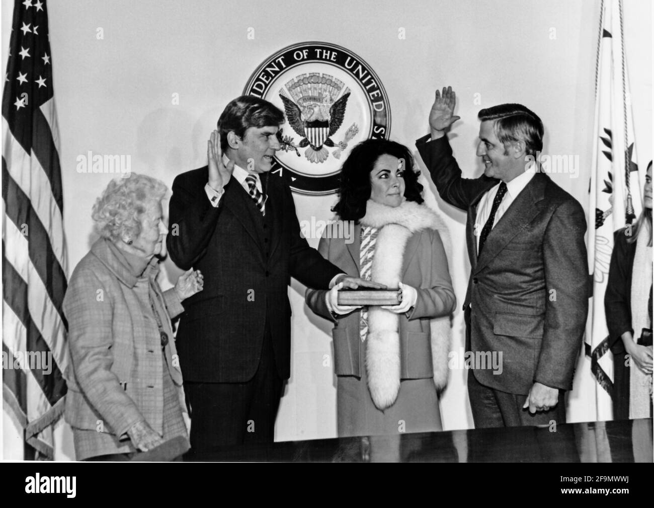 **DATEI FOTO** Walter Mondale ist verstorben. Der Senator der Vereinigten Staaten, John W. Warner (Republikaner von Virginia), links in der Mitte, wird vom US-Vizepräsidenten Walter Mondale, rechts, vereidigt. Warners Frau, Schauspielerin Elizabeth Taylor, rechts, Mitte, und die Mutter von Senator Warner, Mrs. Martha Warner, rechts, schauen am 15. Januar 1979 in Washington, DC nach. Die Zeremonie folgte der offiziellen Vereidigung von Senator Warner in der US-Senatskammer.Quelle: US-Senator Warners Büro über CNP /MediaPunch Stockfoto