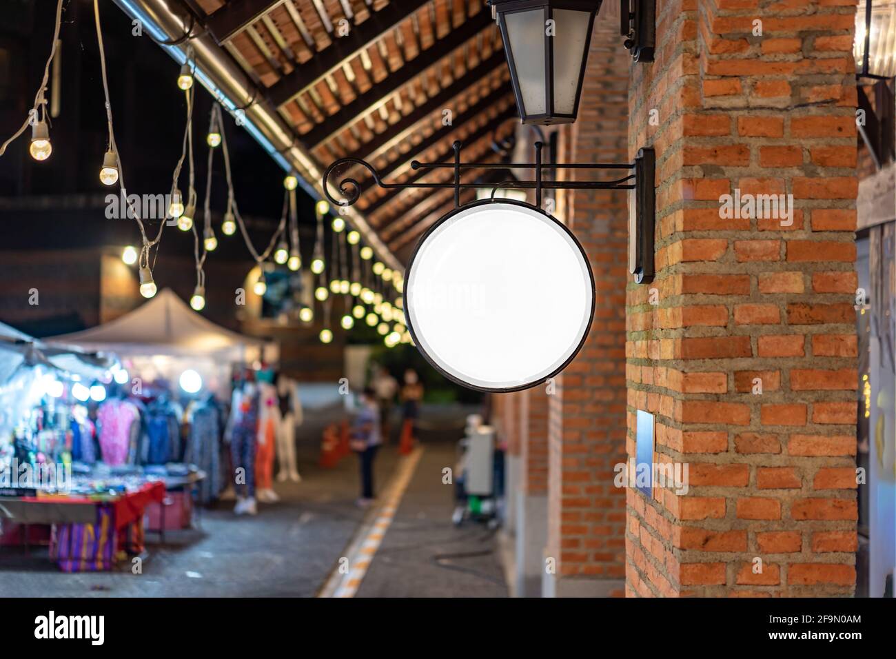 Der Circle White Lightbox hat an der Wand vor dem Backsteinpfosten in einem Tungsten Ambient Umgebung Vintage Shopping Community Mall gehängt. Stockfoto