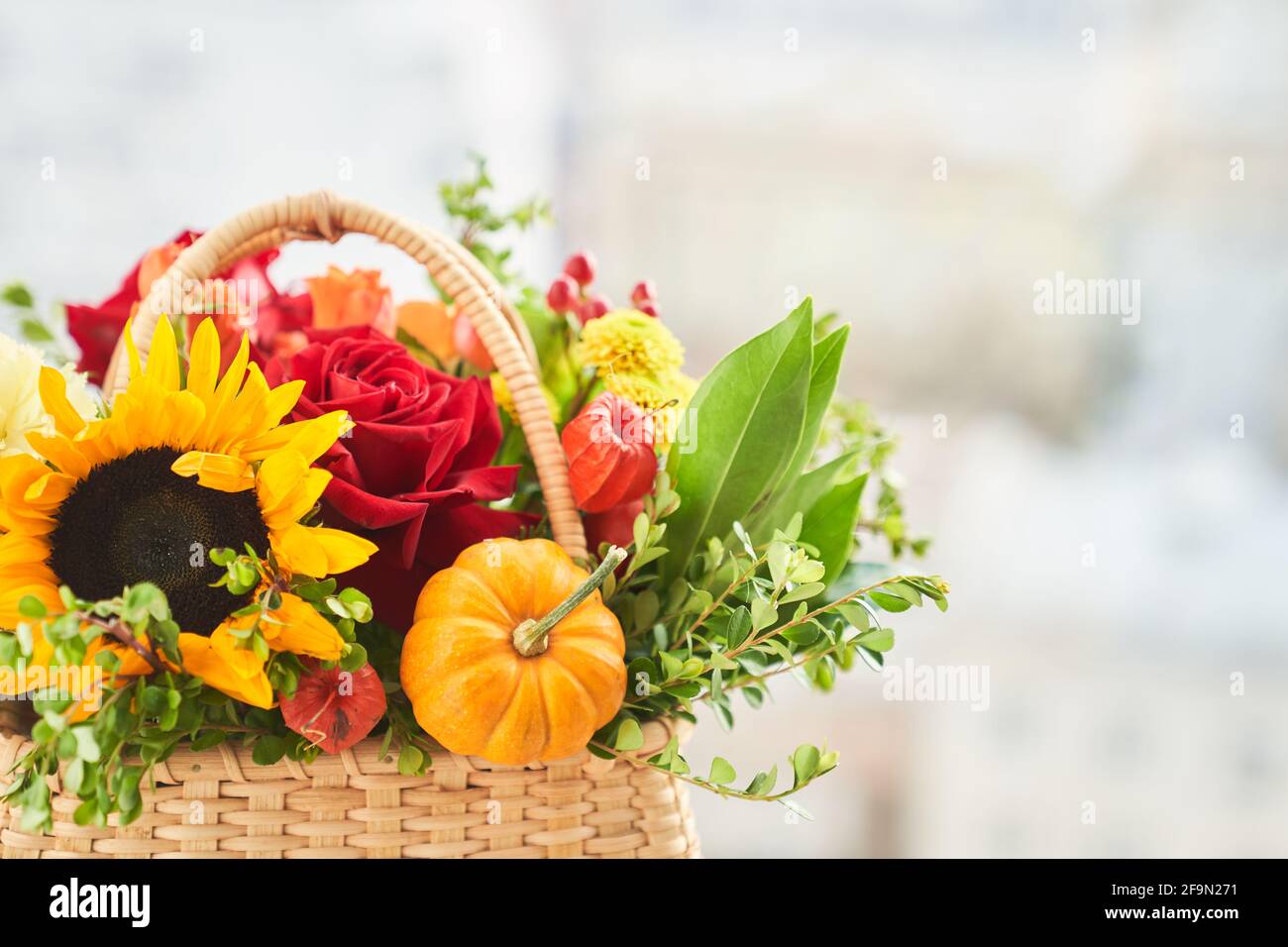 Gemischte Herbstblumen, Sonnenblume, Kürbis, Rose, Physalis im Korb, Bouquet befindet sich auf der Fensterbank mit Kopierfläche. Hochwertige Fotos Stockfoto