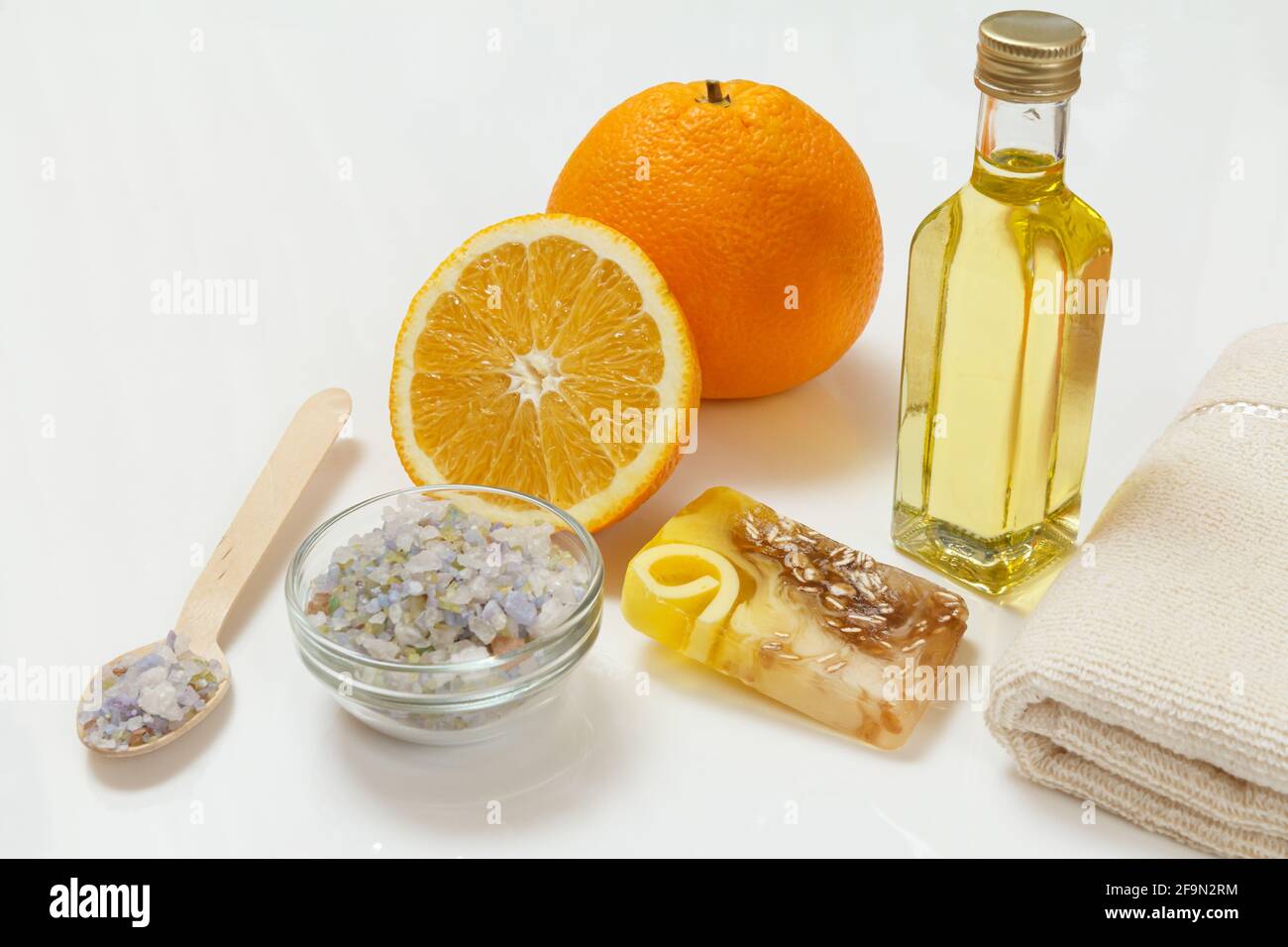 Orange mit einem ganzen, Handtuch, Flasche mit Aromatherapieöl und Meersalz schneiden Stockfoto