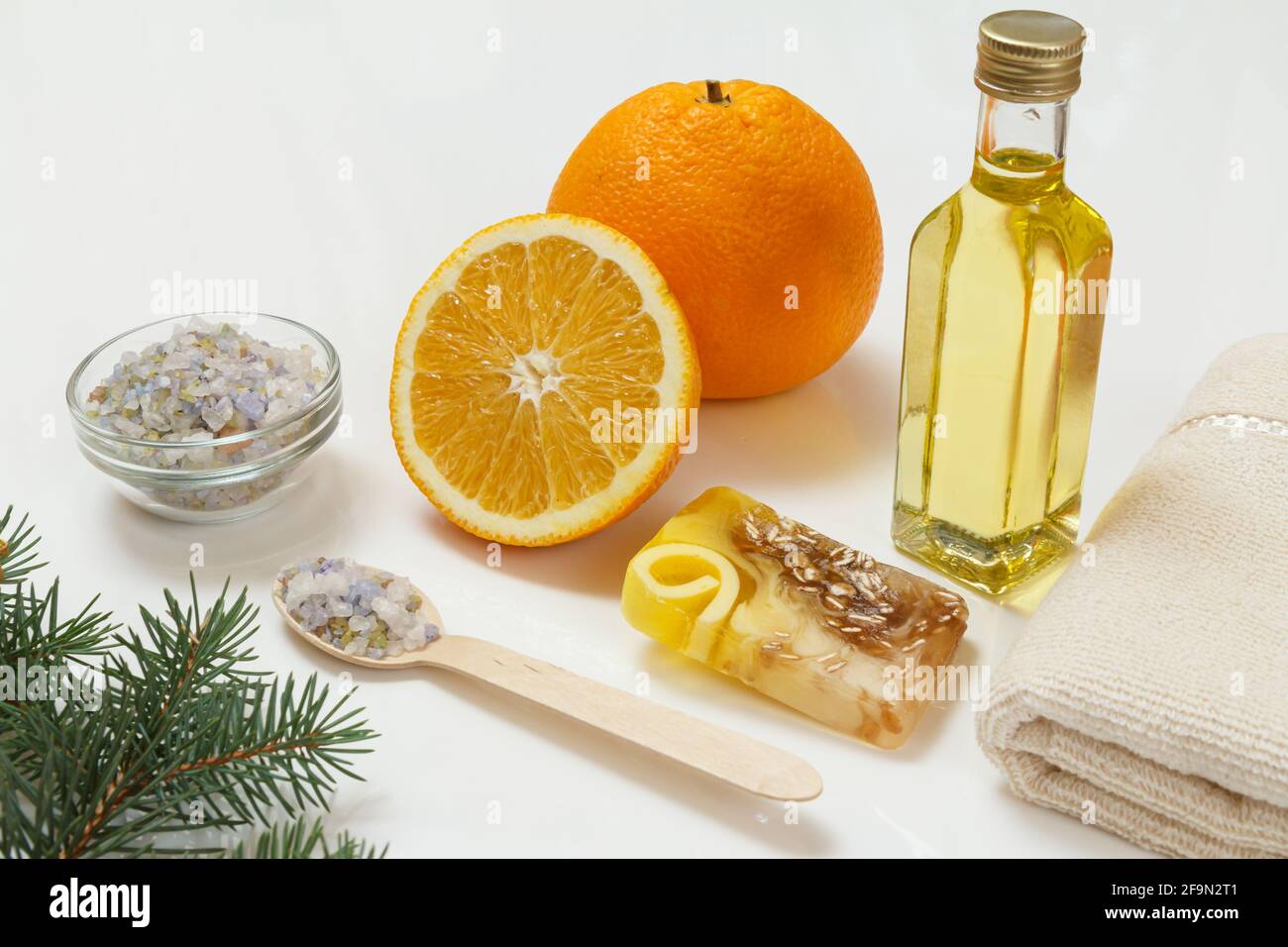 Orange mit einem ganzen, Handtuch, Flasche mit Aromatherapieöl und Meersalz schneiden Stockfoto
