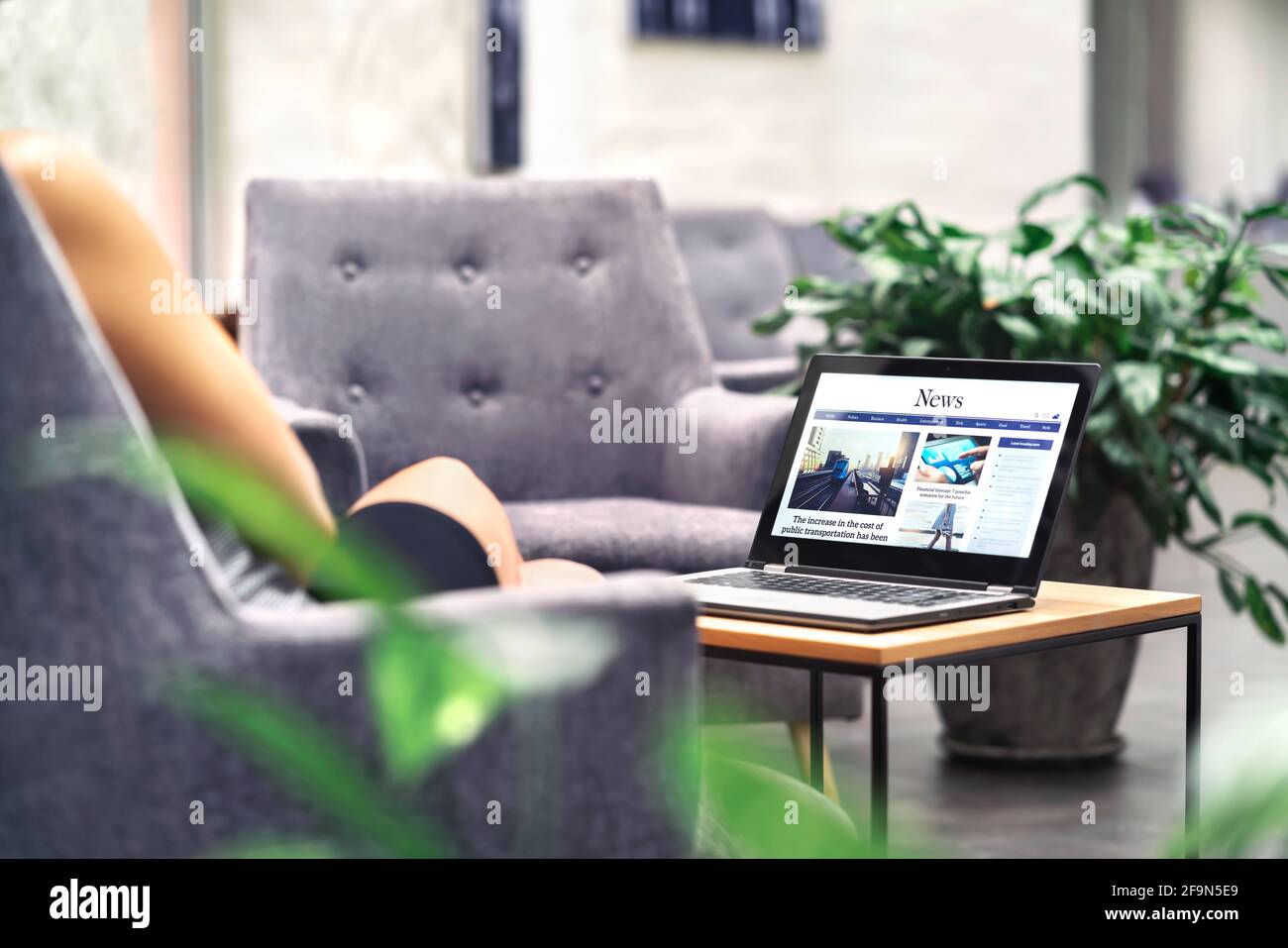 Laptop mit Nachrichten-Website auf dem Bildschirm auf dem Tisch im Business Office, in der Corporate Lounge oder in der Hotellobby. Wireless WiFi des Unternehmens. Modernes Café oder Arbeitsplatz. Stockfoto