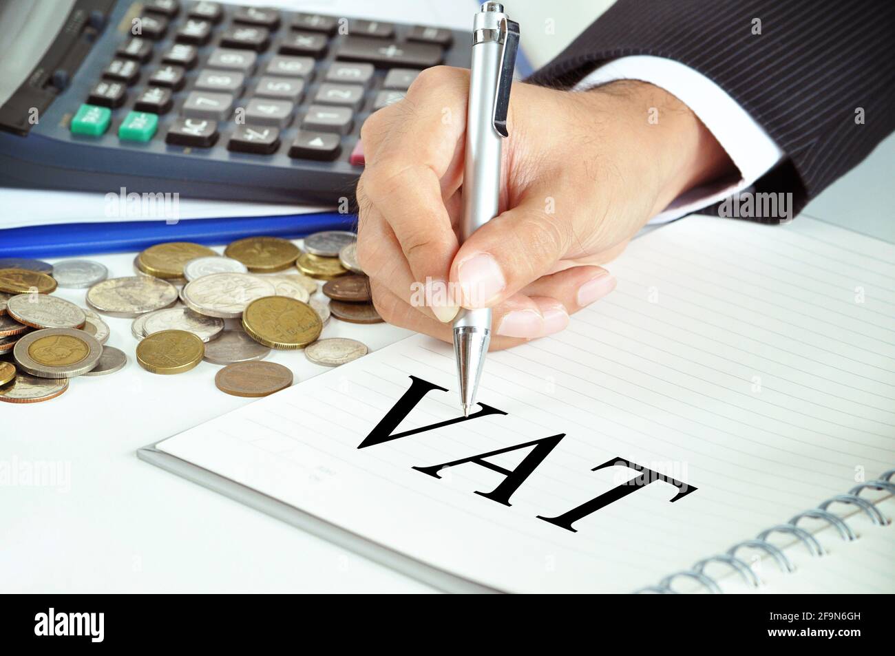 Hand mit Stift, der auf Mehrwertsteuer (oder Mehrwertsteuer) zeigt unterzeichnen Sie das Papier - Handels- und Steuerkonzept Stockfoto
