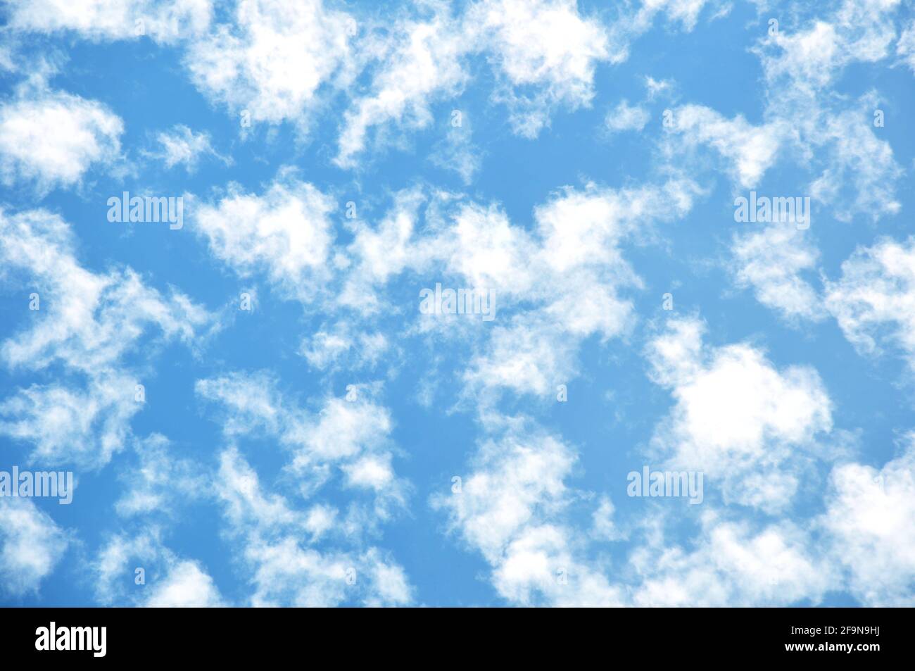 Vereinzelte Wolken auf blauem Himmel Hintergrund Stockfoto