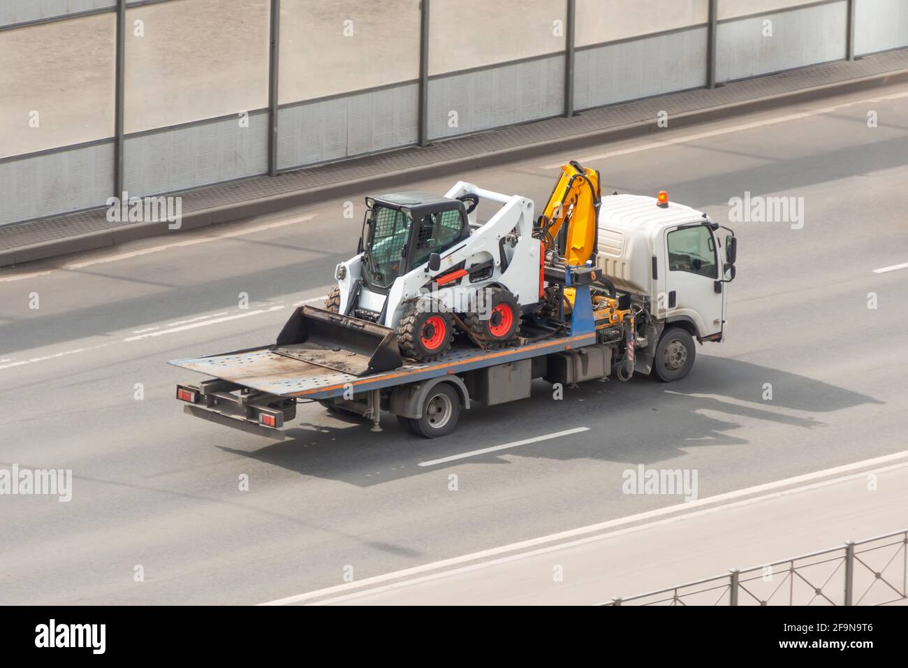 Transport eines Minitraktors mit einem Abschleppwagen Stockfoto