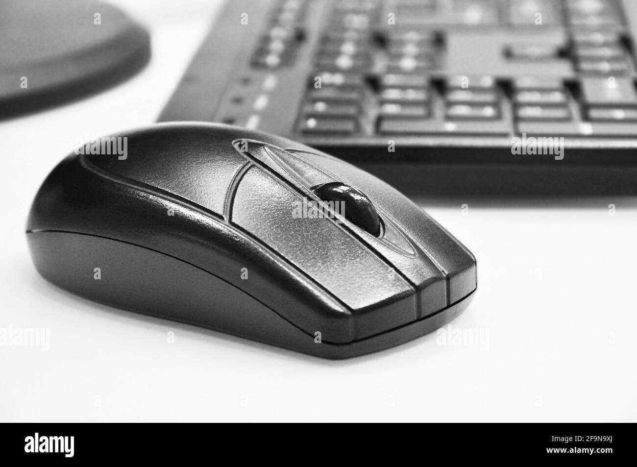 Schwarze kabellose Maus und Computertastatur auf weißem Desktop Stockfoto