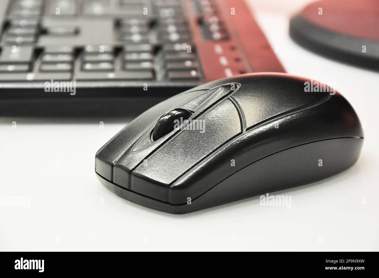 Schwarze kabellose Maus und Computertastatur auf weißem Desktop Stockfoto
